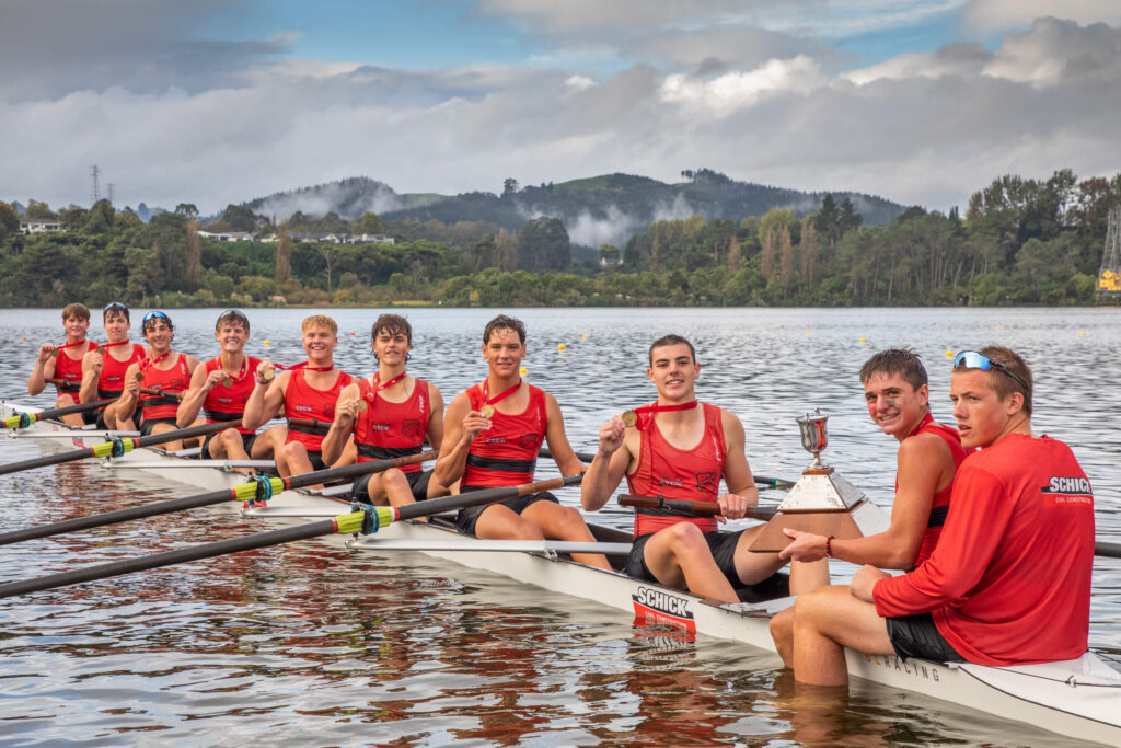 St. Bede's eights sit in their winning SLR boat with their gold medals after winning the Maadi Cup in 2023.